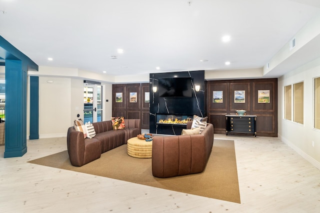 living room with a fireplace and light hardwood / wood-style flooring