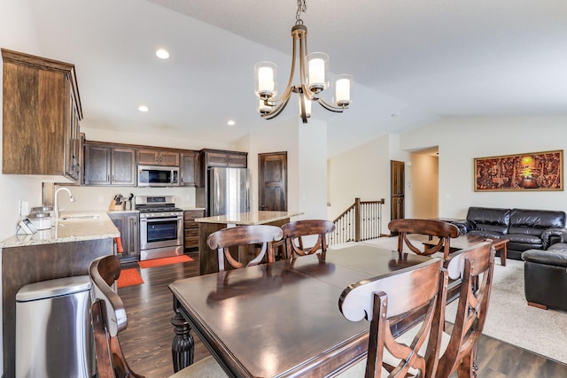 dining space featuring sink, dark hardwood / wood-style flooring, an inviting chandelier, and vaulted ceiling