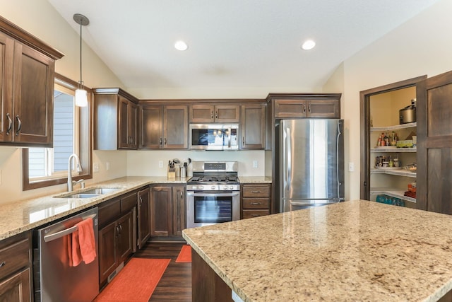 kitchen with decorative light fixtures, dark hardwood / wood-style flooring, stainless steel appliances, sink, and light stone counters