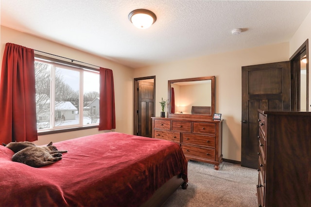 bedroom featuring light carpet and a textured ceiling