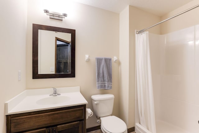 bathroom with toilet, vanity, and walk in shower