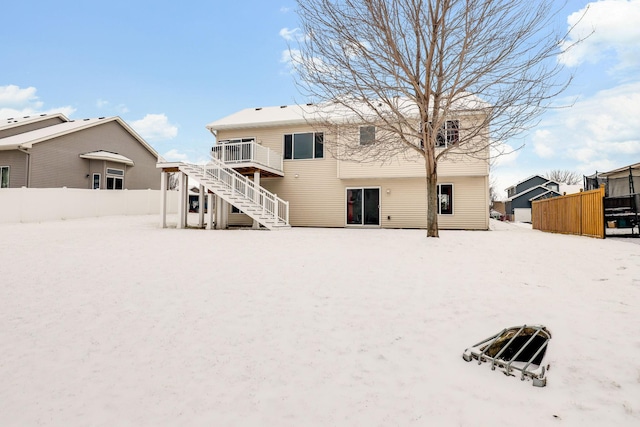 view of snow covered back of property