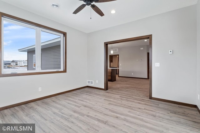 empty room featuring ceiling fan and light hardwood / wood-style flooring