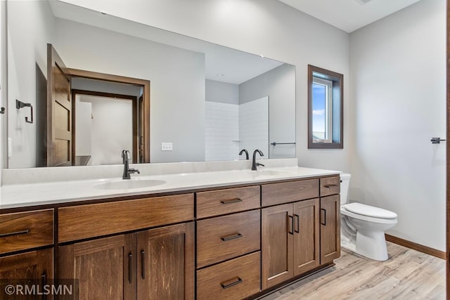 bathroom featuring toilet, wood-type flooring, and vanity