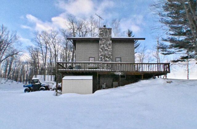 snow covered house featuring a wooden deck