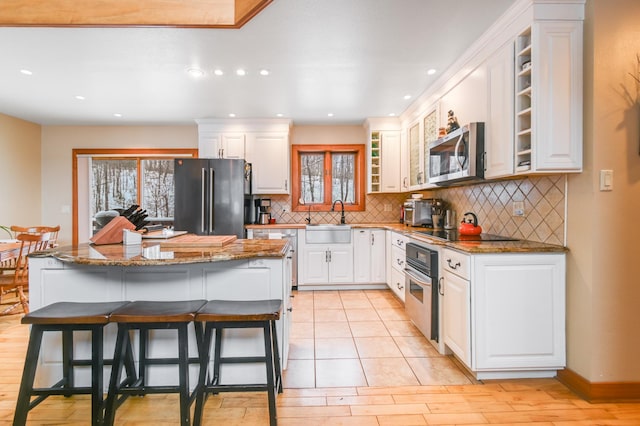 kitchen with white cabinetry, sink, dark stone counters, and appliances with stainless steel finishes