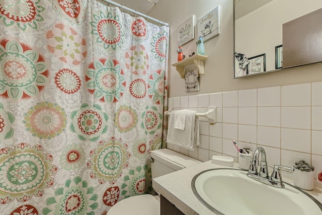 bathroom featuring a shower with shower curtain, vanity, toilet, and tile walls