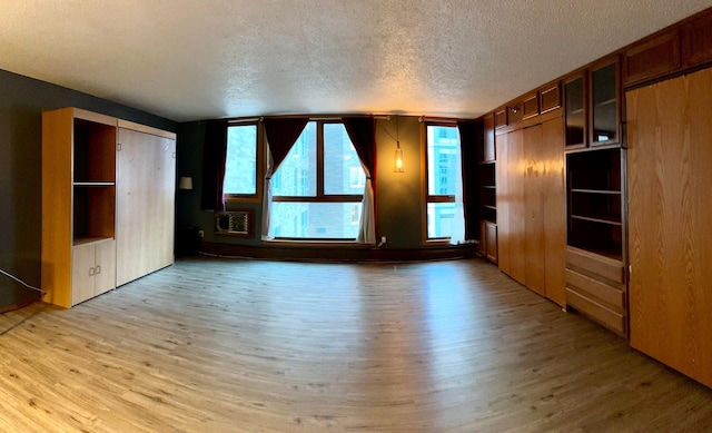 unfurnished living room with a textured ceiling and light hardwood / wood-style flooring