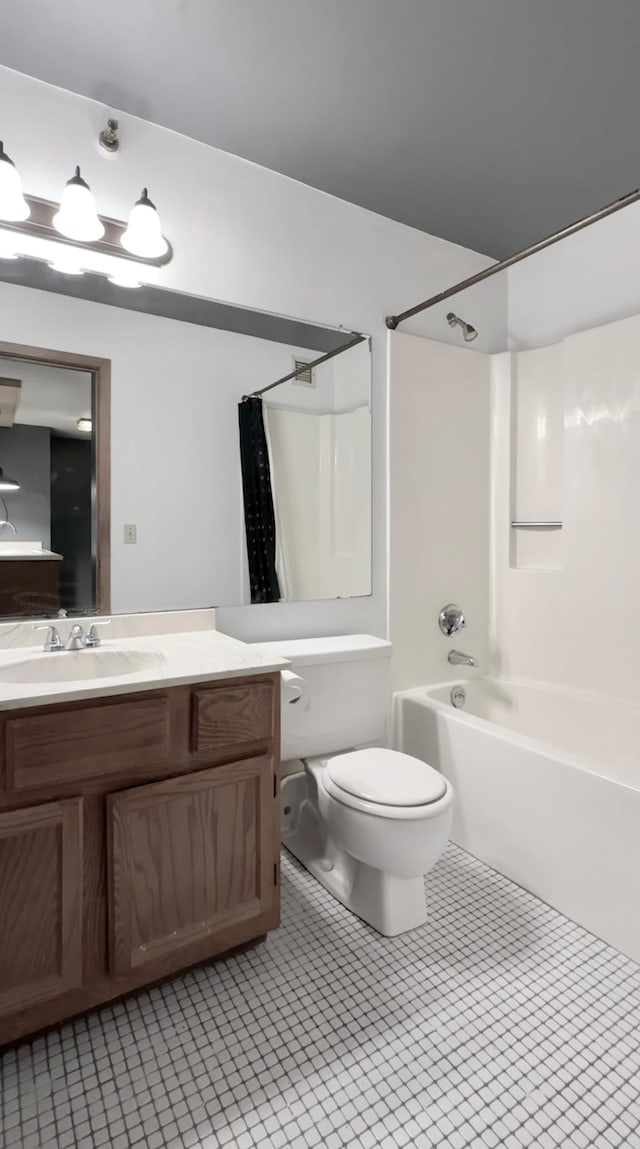 full bathroom featuring toilet, vanity, tile patterned floors, and washtub / shower combination