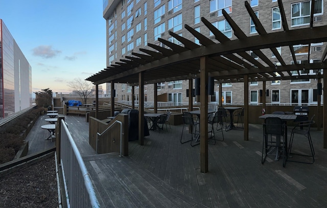 deck at dusk featuring a pergola