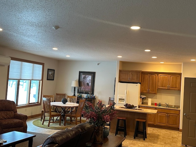 interior space featuring sink, a textured ceiling, and a wall unit AC