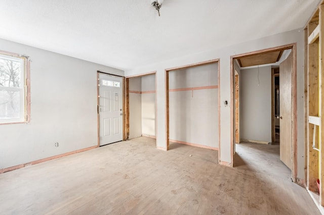 unfurnished bedroom with multiple closets and multiple windows