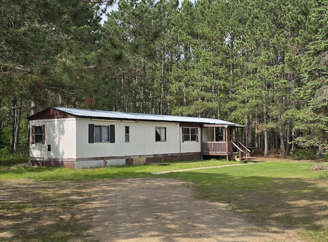 31314 500th St, Cass Lake, MN 56633 - manufactured / mobile home with a forest view, a front yard, and a metal roof