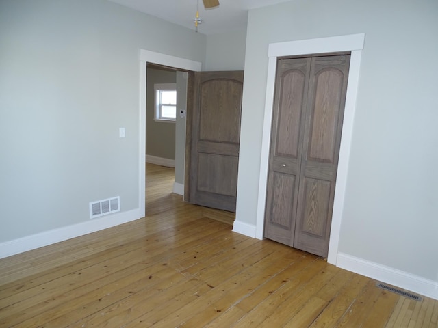 unfurnished bedroom with visible vents, baseboards, and light wood finished floors