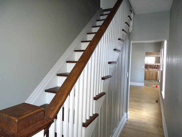 stairway with baseboards and wood finished floors