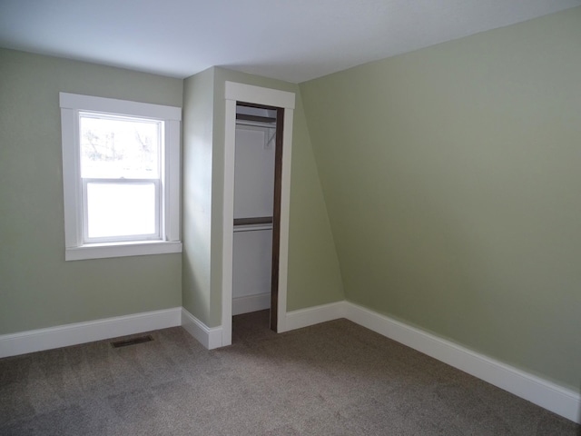 unfurnished bedroom with carpet, visible vents, a closet, and baseboards