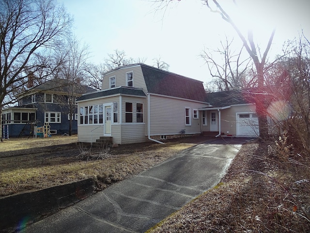 view of side of home featuring an attached garage, a shingled roof, a gambrel roof, entry steps, and driveway