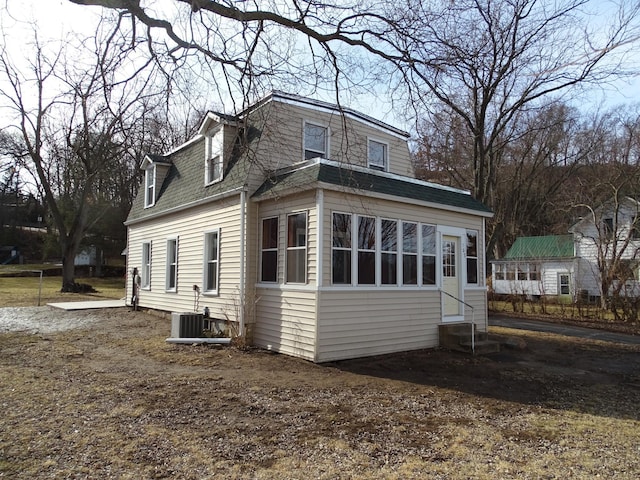 view of home's exterior with central air condition unit, roof with shingles, and entry steps