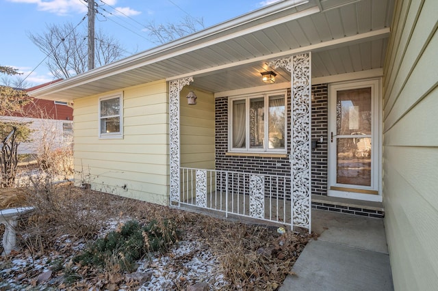 view of exterior entry featuring covered porch