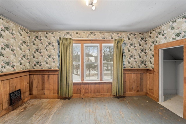 interior space with a closet, a walk in closet, and hardwood / wood-style floors