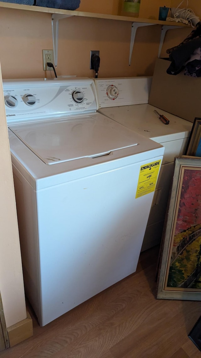 laundry room featuring light wood-type flooring and separate washer and dryer