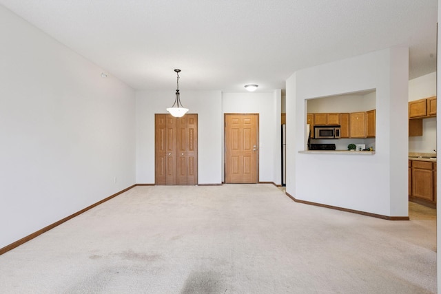 unfurnished living room with baseboards and light carpet