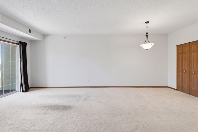 unfurnished room featuring carpet floors, baseboards, and a textured ceiling