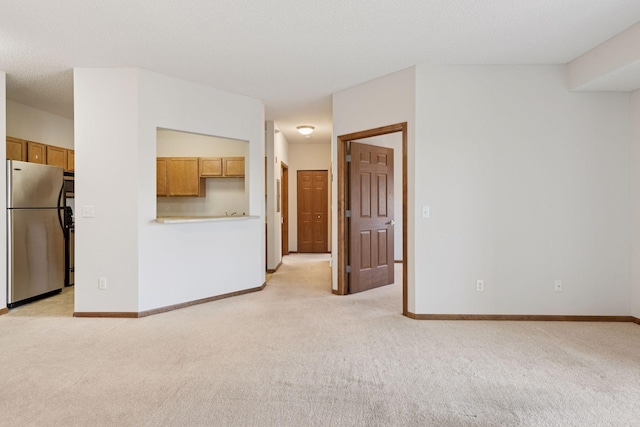 unfurnished living room with baseboards and light colored carpet