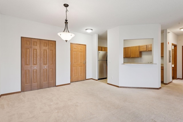 unfurnished living room featuring baseboards, electric panel, and light carpet