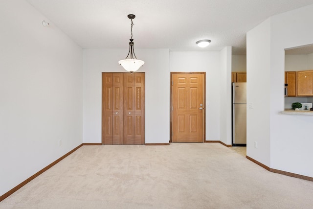 empty room with baseboards and light colored carpet