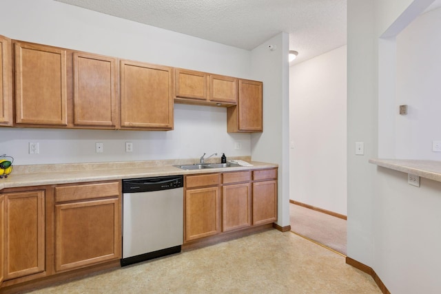 kitchen with brown cabinetry, a textured ceiling, dishwasher, a sink, and light countertops