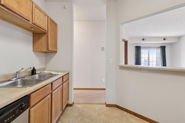 kitchen with a sink, light countertops, a textured ceiling, baseboards, and stainless steel dishwasher