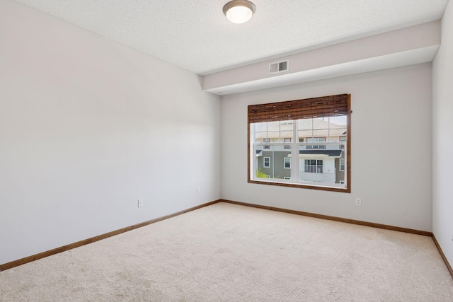 carpeted empty room featuring visible vents and baseboards