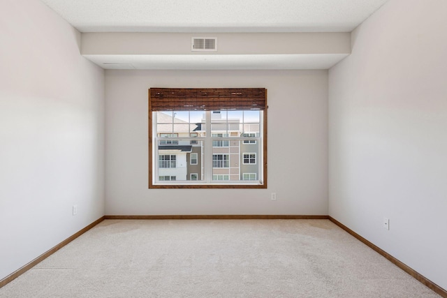 carpeted empty room with baseboards and visible vents