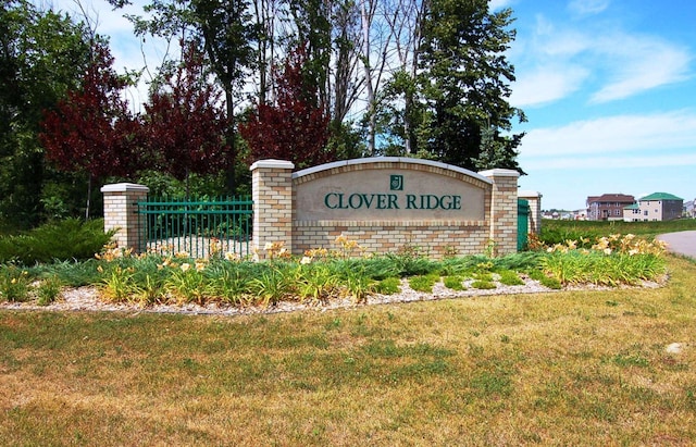 community / neighborhood sign with fence and a yard