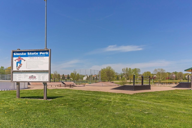 view of property's community with a lawn and fence