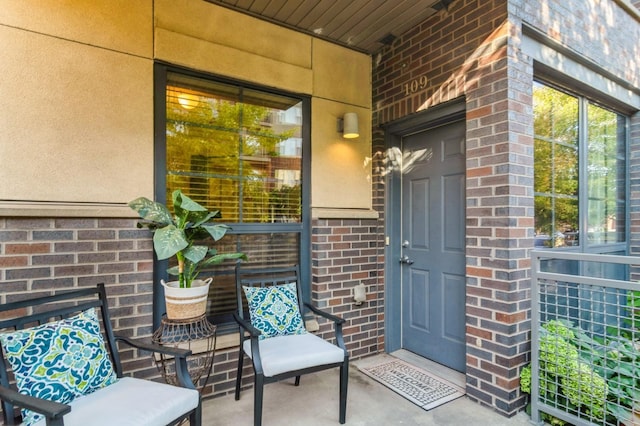 doorway to property featuring brick siding