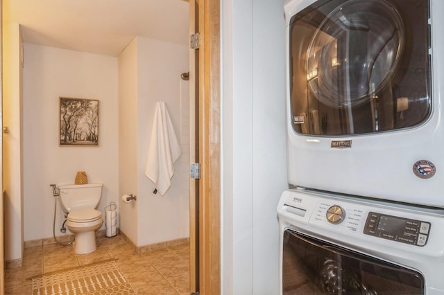 laundry room with laundry area, tile patterned flooring, and stacked washer / drying machine