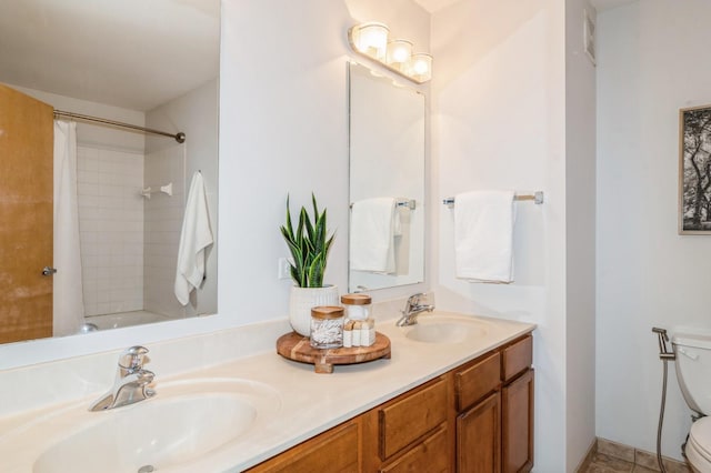 bathroom with a sink, toilet, and double vanity