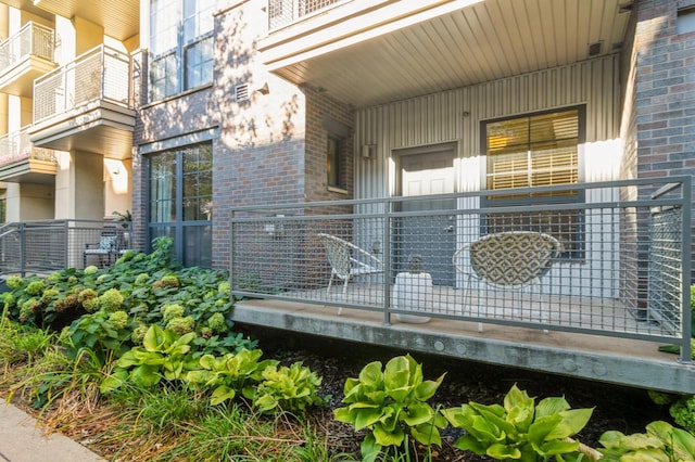 doorway to property featuring a porch and brick siding