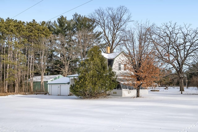 yard covered in snow with a garage and an outbuilding