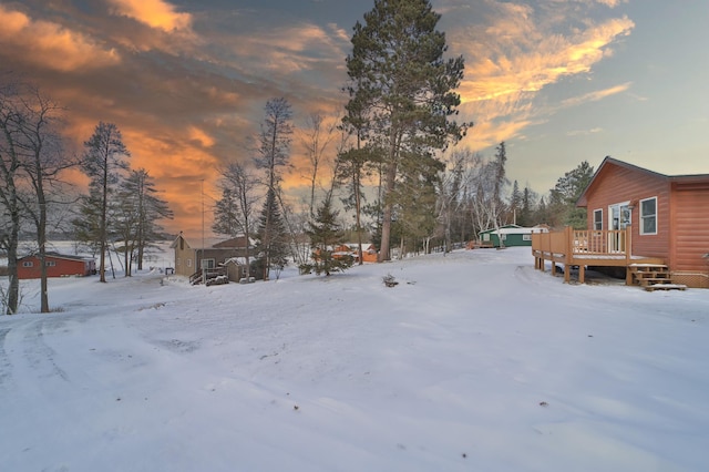 yard covered in snow with a wooden deck