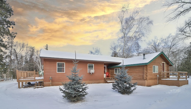 snow covered house featuring a deck