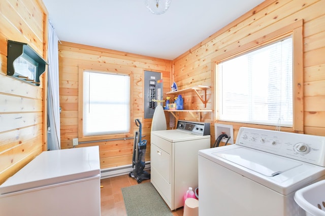 clothes washing area with electric panel, independent washer and dryer, and a healthy amount of sunlight