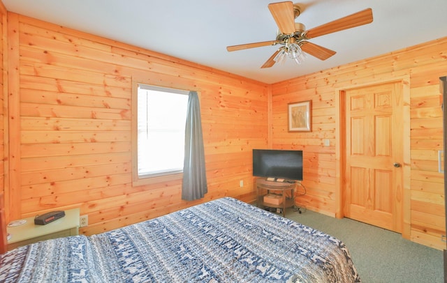 carpeted bedroom with ceiling fan and wooden walls