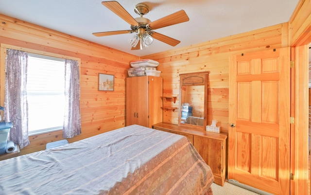 bedroom featuring ceiling fan and wooden walls