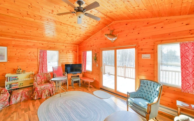 living room featuring lofted ceiling, wood walls, wood ceiling, ceiling fan, and light hardwood / wood-style floors