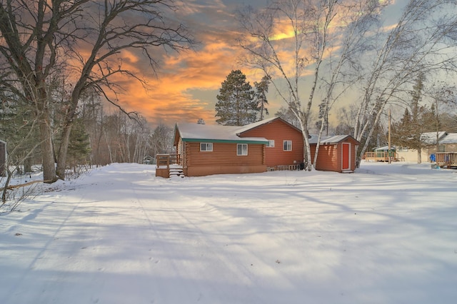 snow covered property with a shed