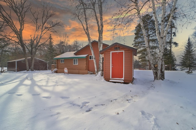 snow covered house with a shed