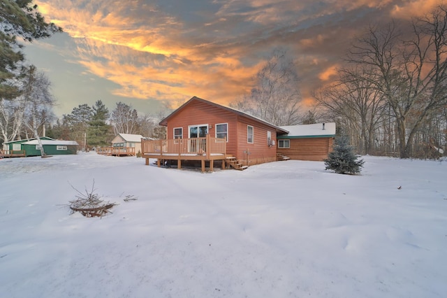 snow covered house with a deck